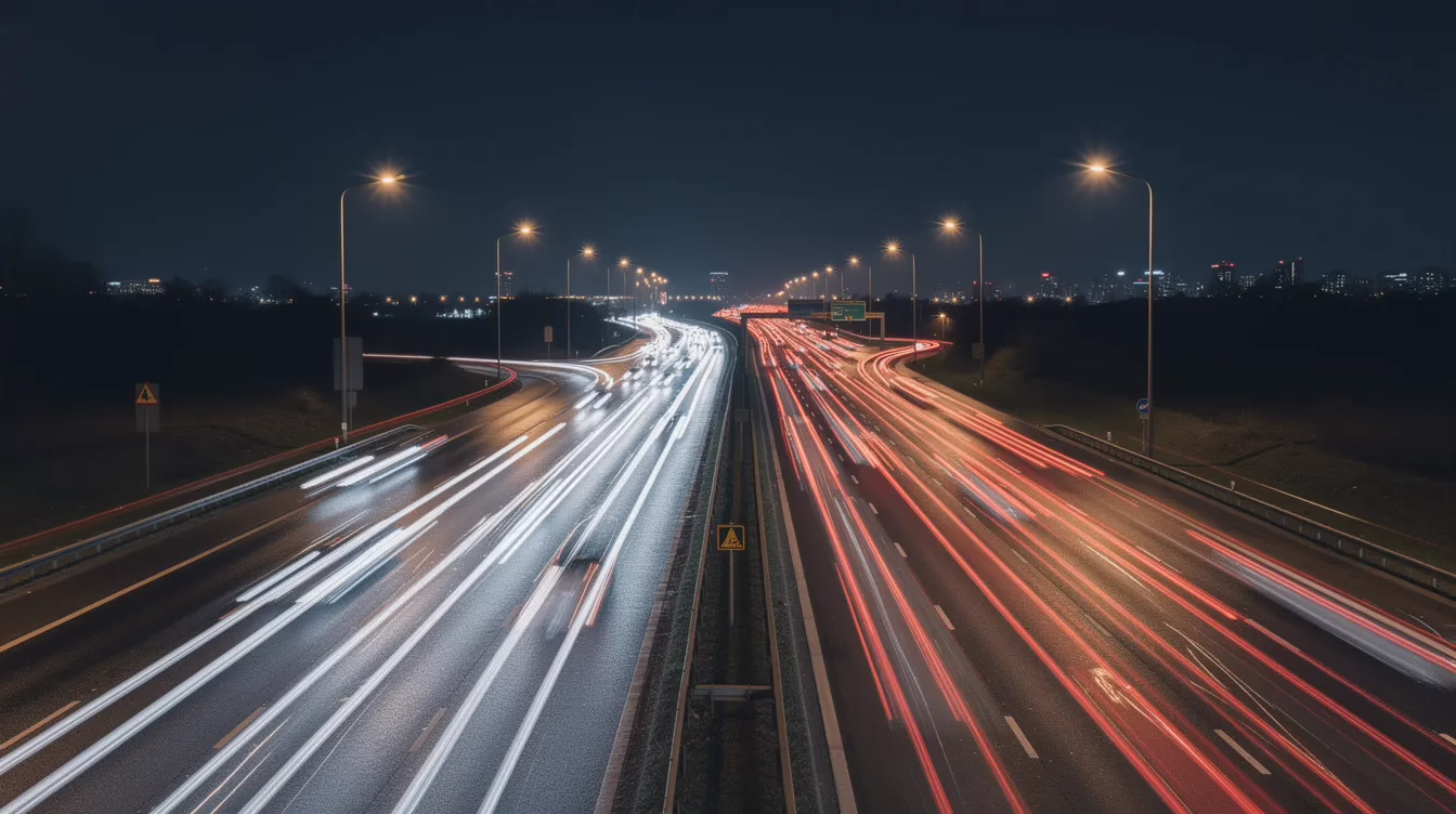 A night-time highway scene depicts a multi-lane road illuminated by the headlights and taillights of various vehicles, creating a dynamic atmosphere. This image highlights the importance of public safety and being aware of your surroundings while driving, especially in urban areas like Utah, where reporting any dangerous incidents can help save lives.