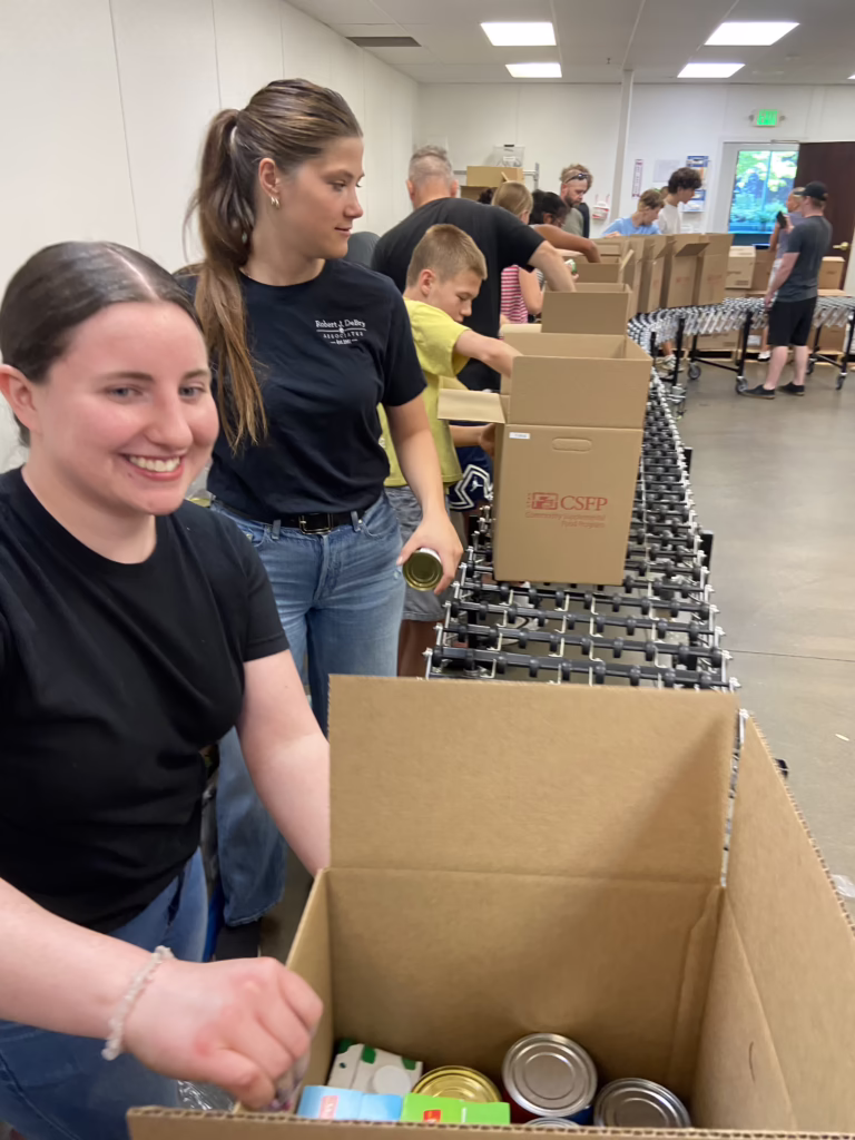 Robert J. DeBry and Associates staff member packing canned food on the Utah Food Bank line