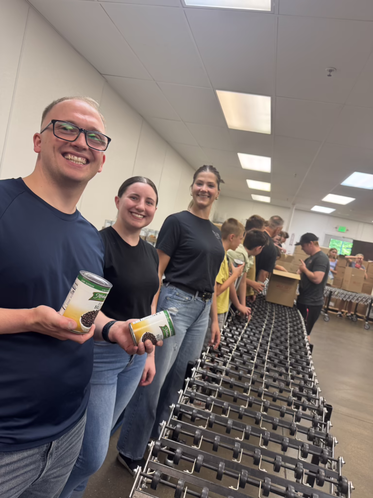 Three Robert J. DeBry and Associates staff members volunteering at the Utah Food Bank
